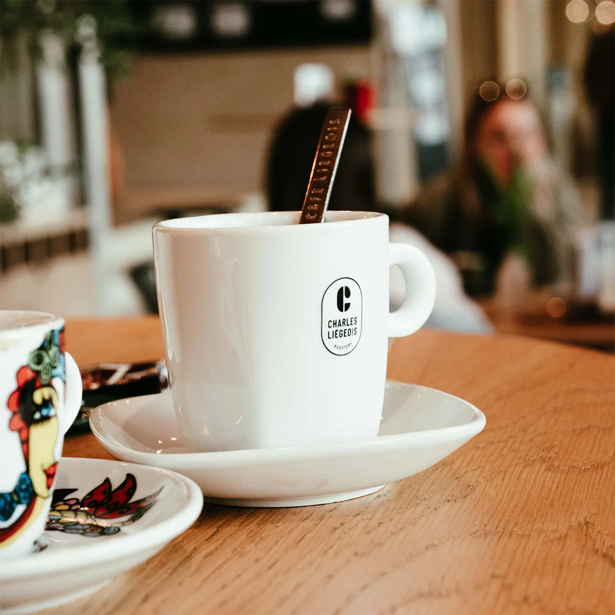 Tasse de café Charles Liégeois sur une table en bois